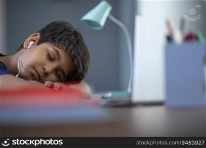 Young boy sleeping in front of the laptop while attending online class 