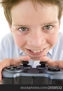 Young boy using videogame controller smiling