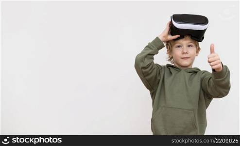 young boy using virtual reality headset showing thumbs up