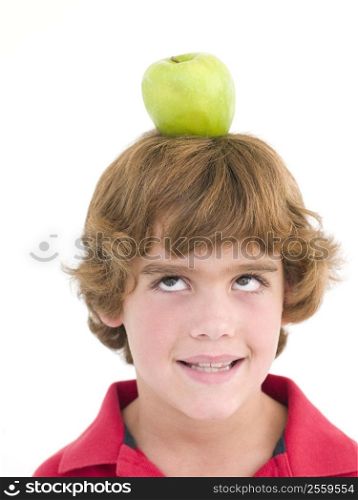 Young boy with apple on his head smiling