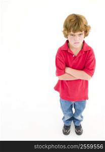 Young boy with arms crossed angry