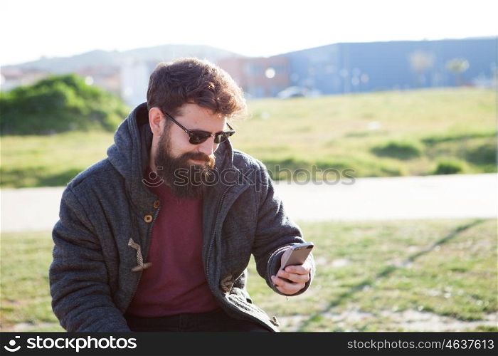 Young boy with hipster look sitting on a bench in street
