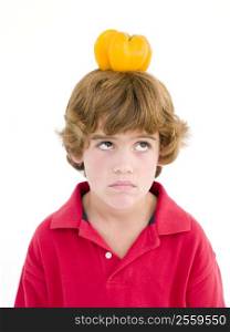 Young boy with yellow pepper on his head frowning