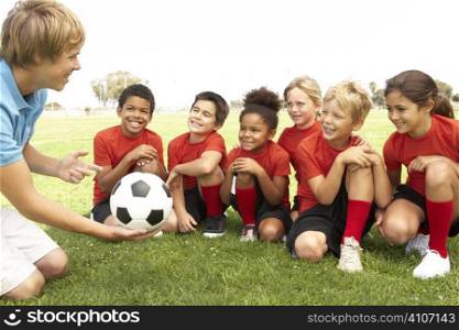 Young Boys And Girls In Football Team With Coach
