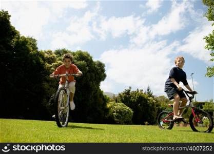 Young boys cycling in park