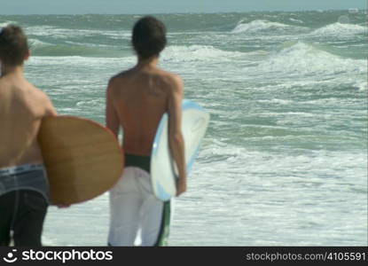 young boys getting ready to go surfing