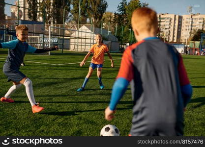 Young boys in sports soccer club on training unit improving skills on natural turf grass pitch at sunny day. Young boys in sports soccer club on training unit improving skills
