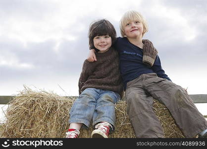Young boys sitting on hay bales