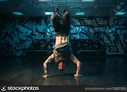 Young breakdance performer, upside down motion. Modern urban dance style. Male dancer