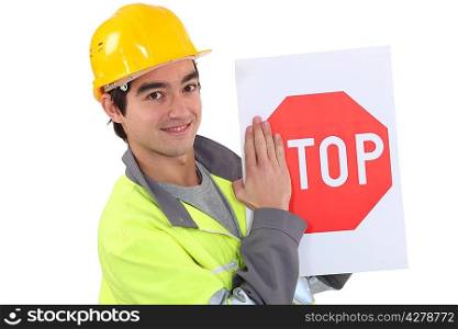 young bricklayer wearing safety jacket and stop sign
