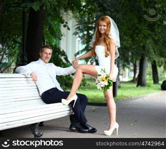Young bride and groom in the summer park