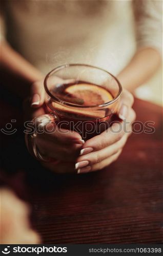 Young bride drinking tea. Wedding bouquet on a wooden table in a restaurant. Cropped image of bride which holding a cup of tea with lamon.. Young bride drinking tea. Wedding bouquet on a wooden table in a restaurant. Cropped image of bride which holding a cup of tea with lamon