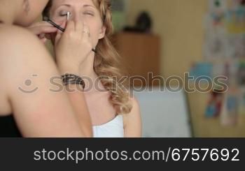 Young bride making her makeup for wedding ceremony