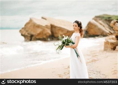 young bride on a sandy beach at a wedding walk