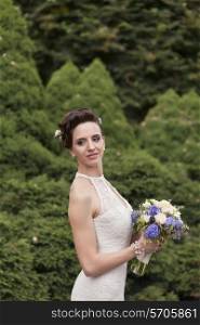 Young bride with bouquet in the park&#xA;