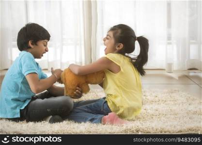 young brother and sister fighting for a toy