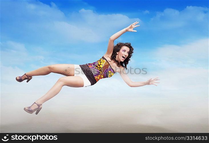 Young brunette beauty jumping over sky background, lots of copy-space