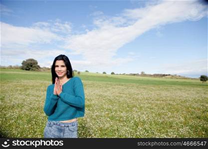 Young brunette girl in the field full of flowers