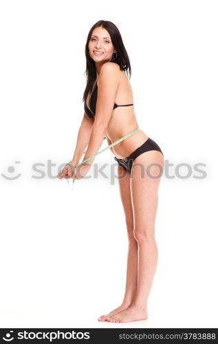 young brunette girl very tiny body in bikini with measuring her waistline a tape