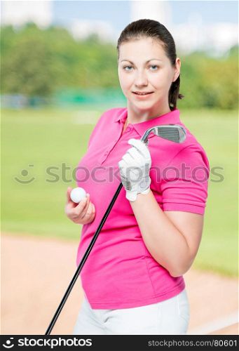 young brunette loves to play golf, posing on a background of golf courses