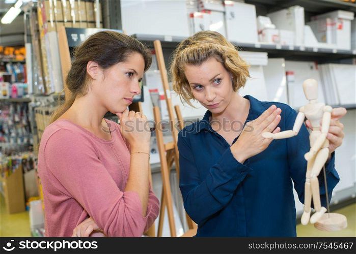 young brunette woman buying drawing model in art department