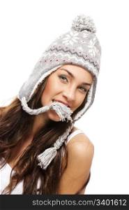 young brunette woman holding part of her winter cap with her mouth. young brunette woman holding part of her winter cap with her mouth on white background