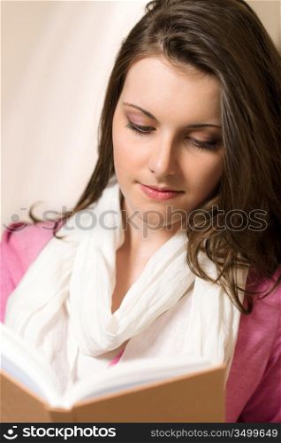 Young brunette woman reading book wear pink jumper