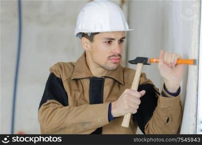 young builder holding chisel and hammer