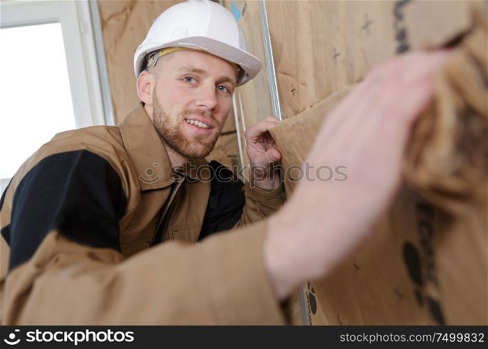 young builder insulating of the walls in the room