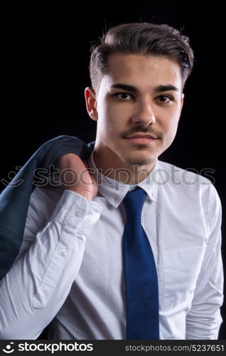 young businesman in suit in black background