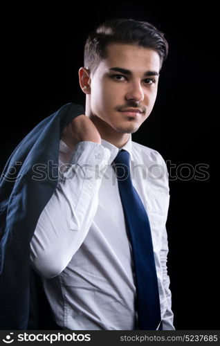 young businesman in suit in black background