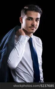 young businesman in suit in black background