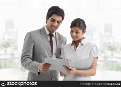 Young business colleagues looking at document in office