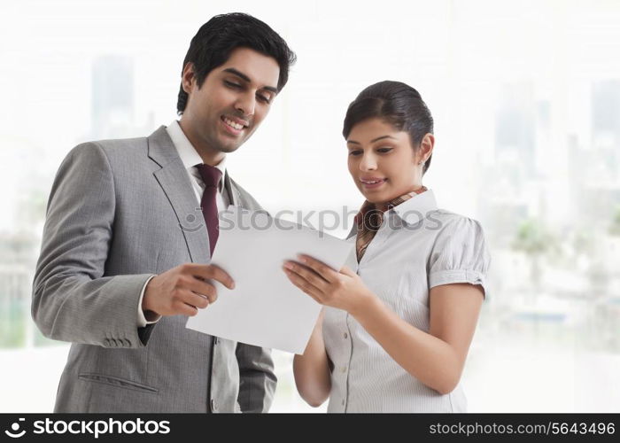 Young business colleagues looking at file in office