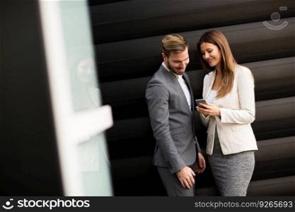 Young business couple looking at the phone