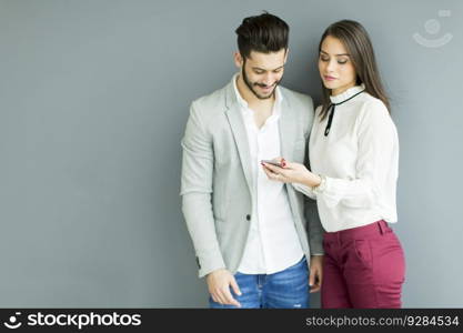 Young business couple looking at the phone in the office