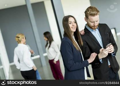 Young business couple looking at the phone in the office