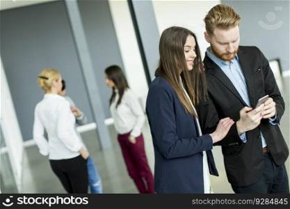 Young business couple looking at the phone in the office