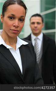 Young business couple stood in front of their office