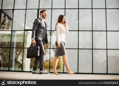 Young business couple walking outdoor near the office building