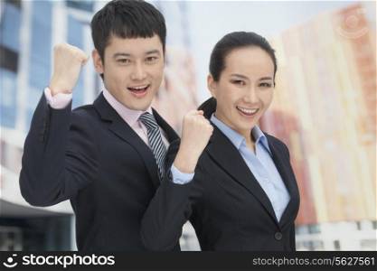 Young business man and woman cheering