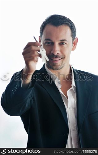 young business man isolated on white holding new home keys and representing sucess in real estate industry