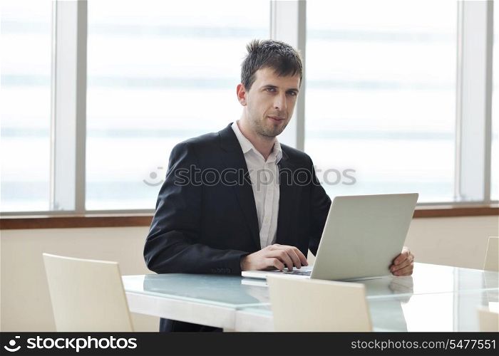 young business man lawyer with laptop alone in big bright conference room