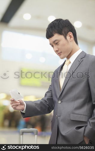 Young business man looking at flight ticket