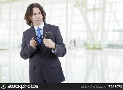 young business man looking worried to his phone at the office
