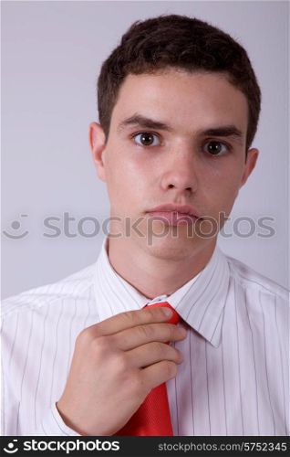 young business man pensive, adjusting his tie