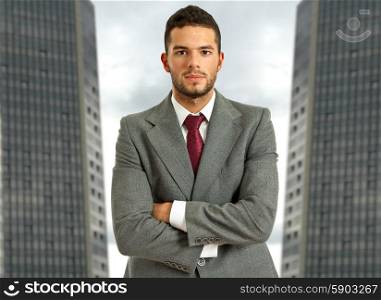 young business man portrait in frint of two buildings