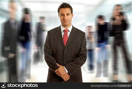 Young business man portrait smilling, among out of focus people
