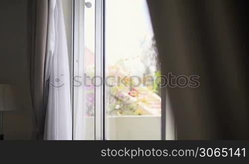 Young business man relaxing and drinking a cup of tea, looking out of window