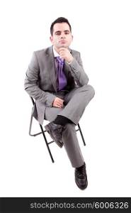Young business man sitting on a chair, isolated over white